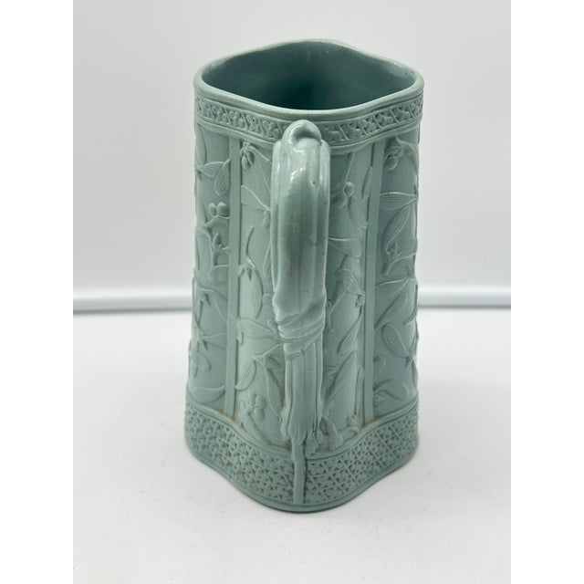 Antique Brownfield & Sons mistletoe pitcher featuring floral and vine embossed designs. Tapered body with a curved handle...
