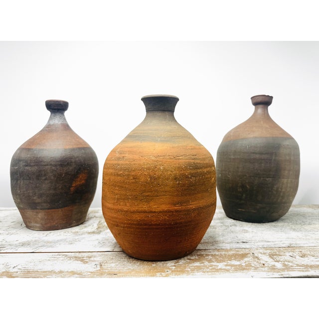 An unglazed earthenware vessel with a flared lip and burnished reddish-brown surface. Likely used as a utilitarian water...