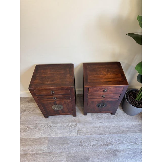 Pair of Asian inspired design wooden bedside tables. These are great practical units each including two smooth sliding...