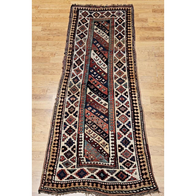 A beautiful and colorful vintage Caucasian Gendje Kazak runner from the late 1800s in excellent pile condition, featuring...