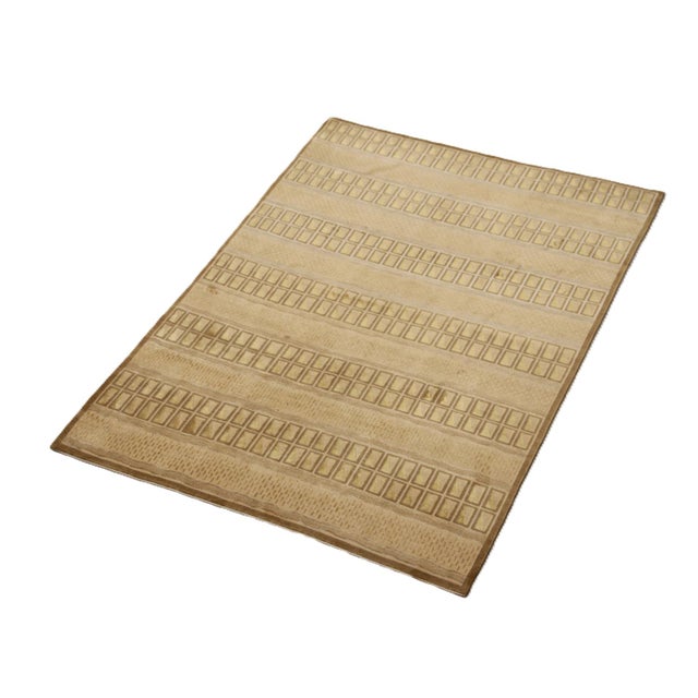 A refined composition of architectural precision and tactile softness, this 6'x9' hand-knotted rug from the Ariana Modern...