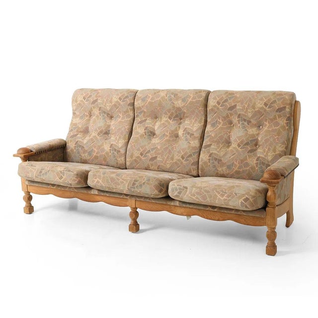 A Danish mid century modern sofa with a tufted back cushion upholstery on a well made wood (oak) base. The sofa has bottom...