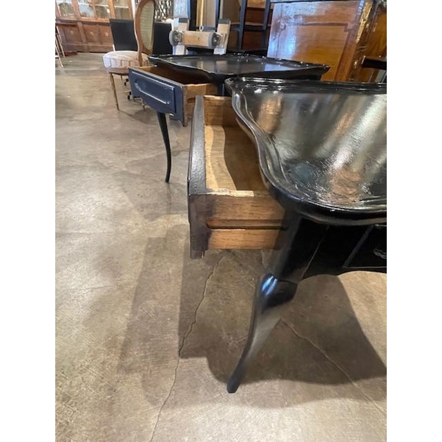 This pair of vintage French black lacquered side tables is a stylish addition to any home decor. With the sleek black...