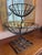 Vintage sculptural two-tier fruit stand or centerpiece basket crafted in hand-forged iron. The organic vine-form stem,...