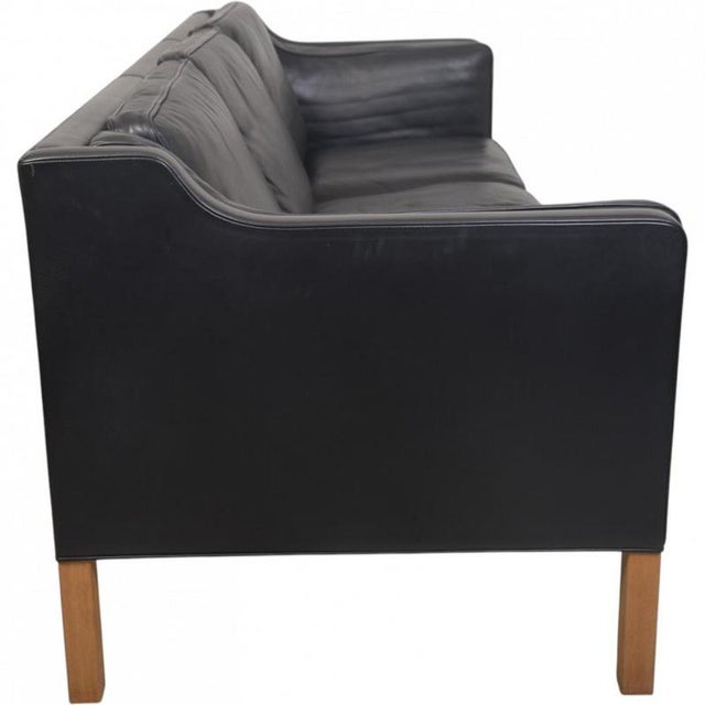Børge Mogensen 2213 3.seater sofa upholstered in black leather and with legs of oak. The sofa is from 2001 and appears in...