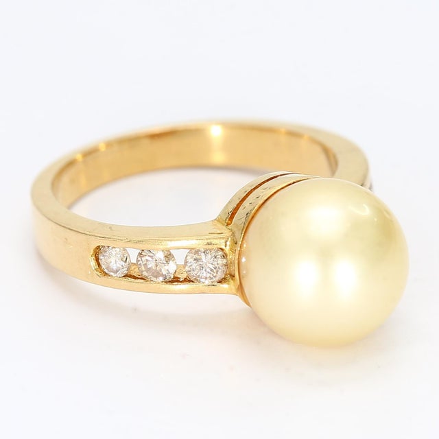 Here is a nice classic style 18k yellow gold ring with diamond accents flanking a central yellow pearl. - Stone Info - 1x...