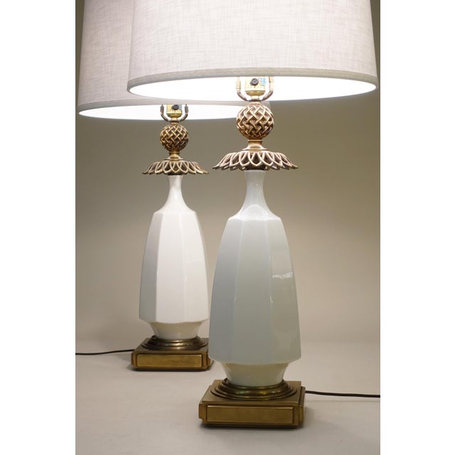 A bold and impressive matched pair of vintage Hollywood Regency Modern Brass & White Porcelain Classical Pineapple form...
