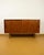 A small danish teak sideboard with two sliding doors and square teak button handles—a detail that reveals its quality...