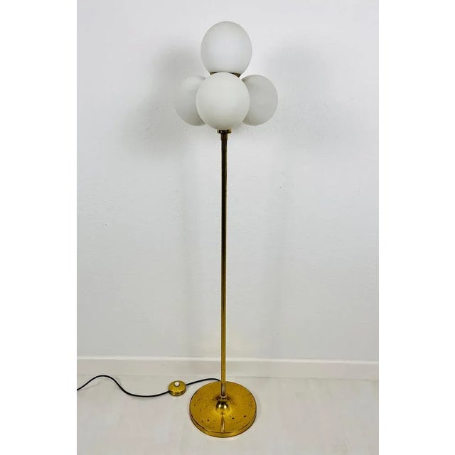 A mid-century floor lamp by kaiser made in germany in the 1960s. It is fascinating with its space age design and four ball...