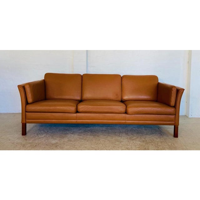Made in Denmark by Morgans Hansen, this is a beautiful vintage Danish classic 3 person sofa upholstered in soft Cognac...
