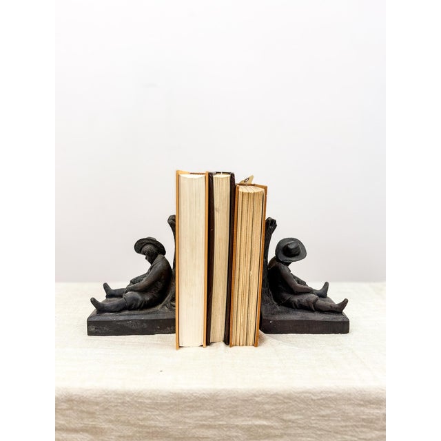Bring vintage charm and character to your bookshelf or desk with this pair of cast metal bookends featuring a sleeping man...