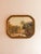 Color print of a romantic river landscape with figures on the rocky bank, sheep beyond and wooded hills under a hazy sky....
