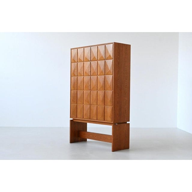 Striking Mid-Century highboard, crafted from warm oak and showcases a bold Brutalist aesthetic, produced in Germany around...