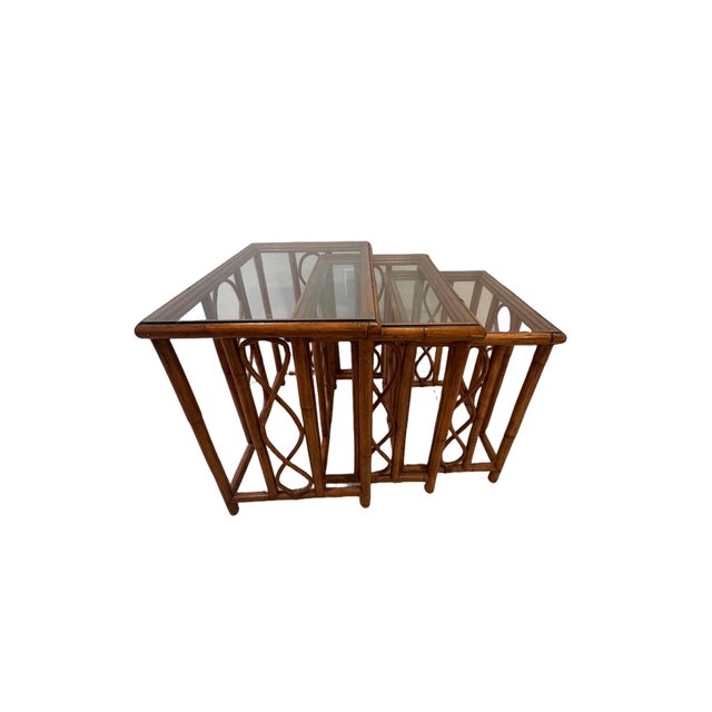 A charming set of three vintage nesting tables dating to the 1970s, featuring beautifully crafted burnt bamboo and rattan...