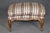 This handsome French Louis XV-style walnut bergère with matching ottoman, dating to approximately the 1950s, is an...