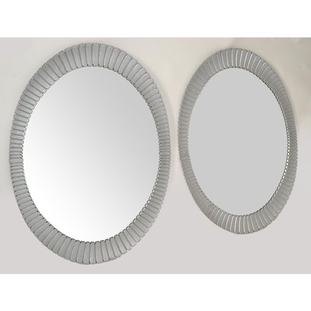 Pair of Decorative Large Hollywood Regency Style Oval Wall Mirrors. Each mirror has a decorative plastic frame made up of...