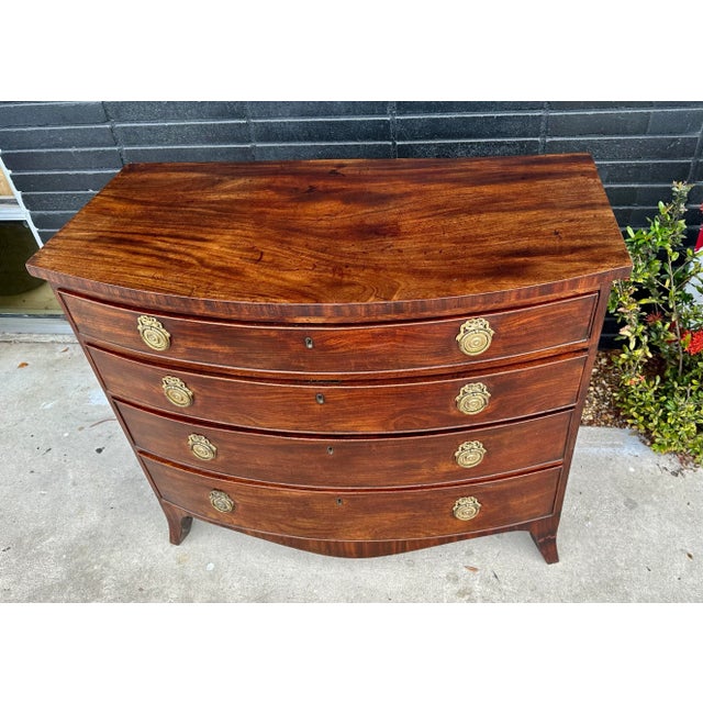 A most elegant 19th century English mahogany chest of drawers, notable for its graceful form and refined presence. The...