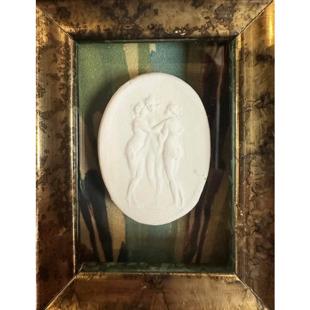 A charming, petite framed grand tour style intaglio. Features a white plaster intaglio of the Three Graces mounted on a...