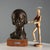 Bronze sculpture on a wooden base depicting a girl's head, titled 'Erminia'. Engraved signature. This piece is attributed...
