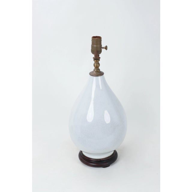 Tear drop shaped white porcelain vase lamp. This vase lamp appears luminescent due to the bright white color and features...