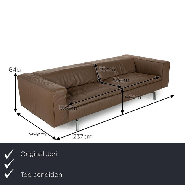 The Shiva sofa from Jori is covered in brown genuine leather and stands on metal feet. The minimalist design characterizes...