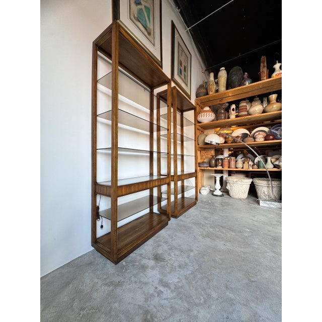 A striking pair of 1970s mid-century modern étagères featuring sleek oak wood frames, six - tiers with four smoked glass...