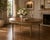This exceptional antique dining table, likely from the 1910s–1920s, embodies neoclassical elegance with a richly figured...