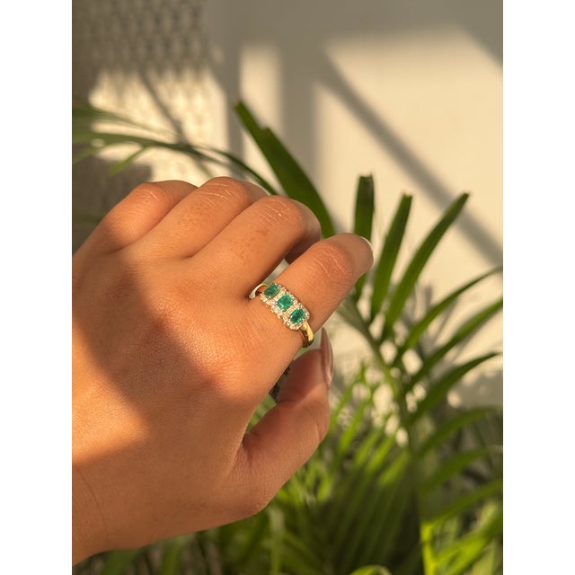 This three stone ring is featuring 0.8 carat emeralds set in 14K yellow gold. Each emerald measuring approximately...