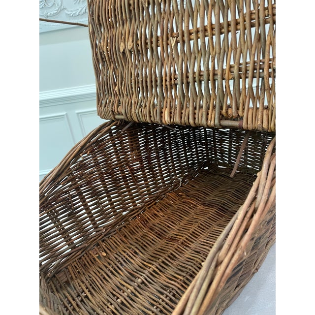 This large vintage split-lid willow basket is a rustic piece, with sturdy construction, and boasts an expert weaver's...