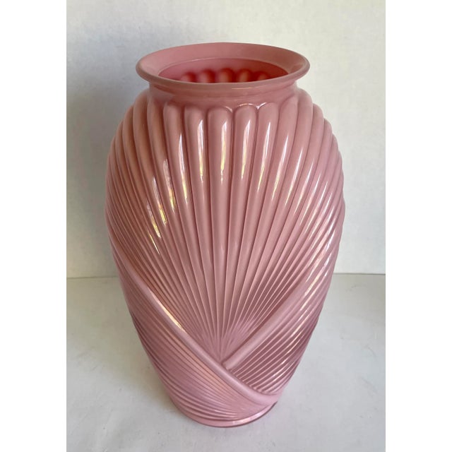 Here is a stunning pink glass vase with ribbed details that look like draped fabric... or perhaps you see a shell or fan...