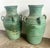 Pair of large ceramic urns, each with a robust, rounded body and a narrow, flared neck. The urns are finished in a...