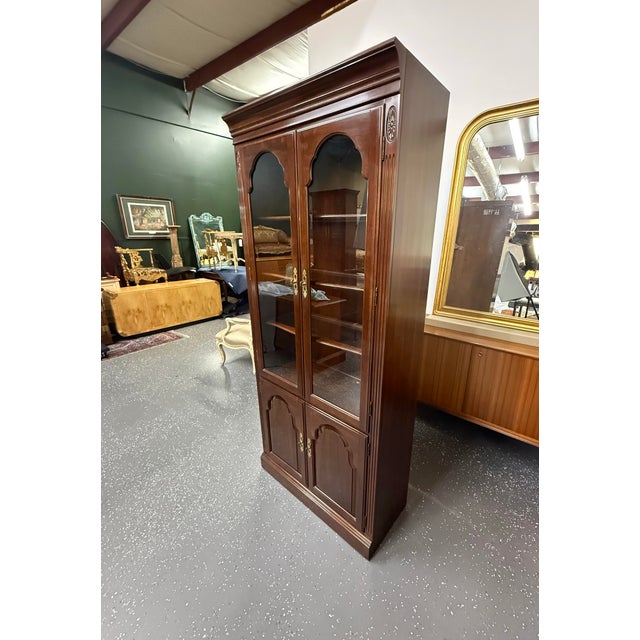 Beautiful Ethan Allen Georgian Court cherry wood display cabinet. It features a high quality glass door cabinet with...