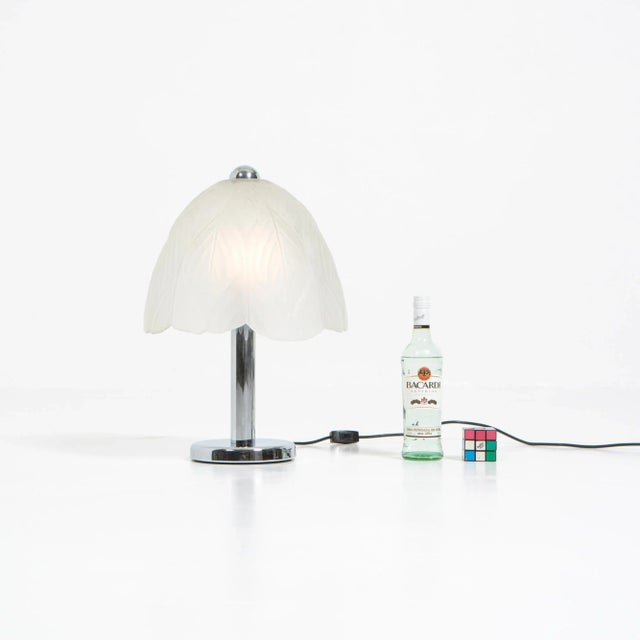 This decorative table lamp was created by Peill & Putzler in the 1960s. The glass is decorated with a pressed leaf...