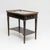 Slender side table of rectangular form with a marble top and a surrounding gallery. The top features two round openings...