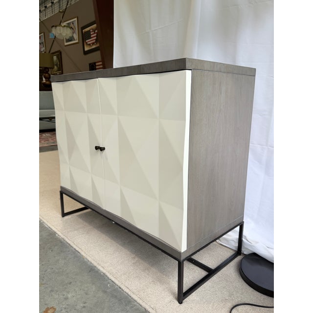 A striking Ethan Allen Ravenswood media cabinet showcasing bold contemporary styling with sculptural geometric door fronts...