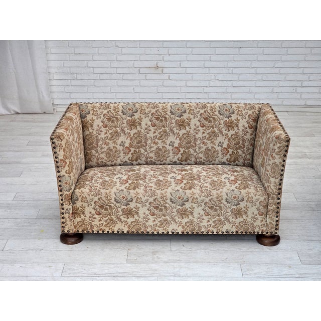 1950s, Danish 2-seater sofa. Beige/ brown furniture fabric, oak wood legs, brass springs in the seat. Sofa was...