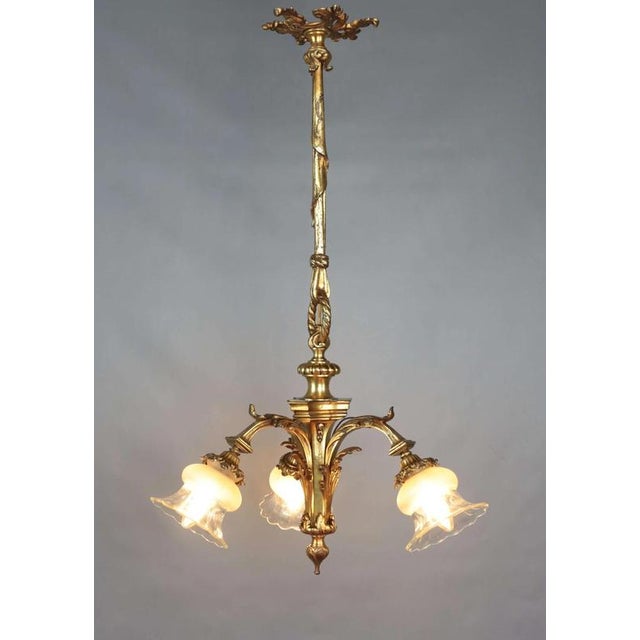 Small mazarin-type chandelier made of gilded bronze. The chandelier is very well cast. The shades are glass, partly etched...