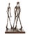 This modern dark patinated bronze sculpture is a figurative artwork depicting three elongated male figures walking...