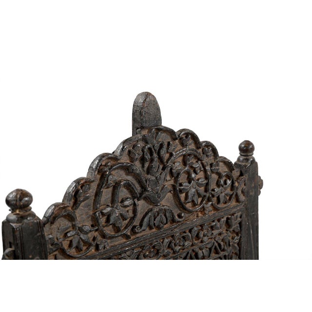 This Vintage Indian Carved Teakwood Pita Chair features an intricately hand-carved teakwood backrest, handwoven natural...