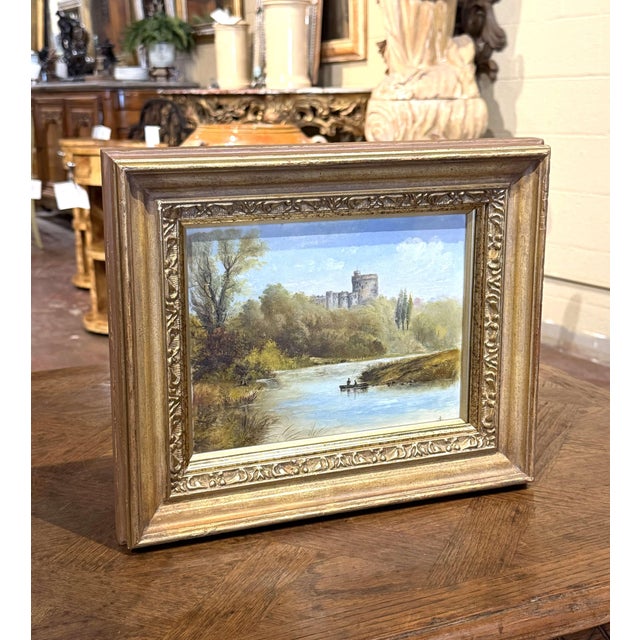 This charming antique landscape painting captures a peaceful English countryside scene with a medieval castle overlooking...