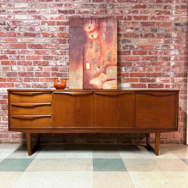 Vintage mid-century modern teak sideboard or credenza manufactured by Stonehill Furniture of London. Features include:...