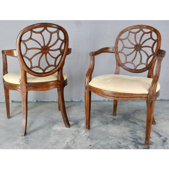 We are offering a pair of elegant spider back or wagon wheel Hepplewhite chairs from the early 20th century. The centre of...