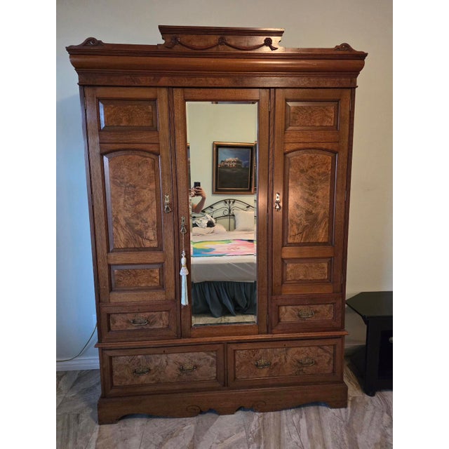 An absolute showstopper of late 19th-century craftsmanship, this magnificent Victorian-era grand wardrobe armoire is a...