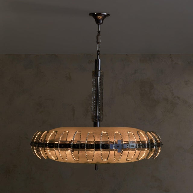 An Italian chandelier from the 1960s, in the manner of Fontana Arte, defined by its elongated, horizontal form and layered...