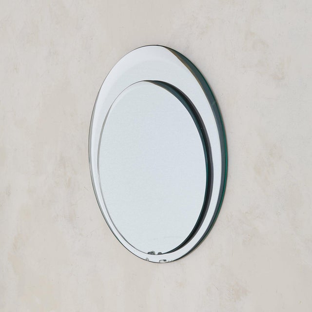 A 1960s Italian wall mirror attributed to Cristal Arte, composed of two concentric layers of bevelled glass. The outer...