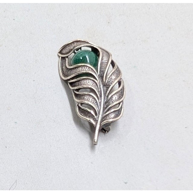 1960s sterling silver feather with single faux-jade bead brooch with security clasp. Marked "NAPIER STERLING ©" on the...