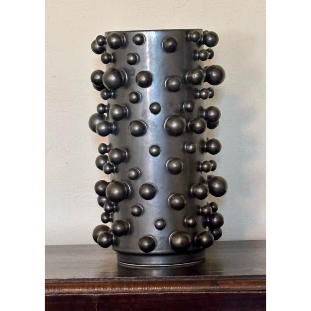 A striking fusion of modern texture and edgy sophistication, this cylindrical ceramic vase by Studio A Home (a division of...