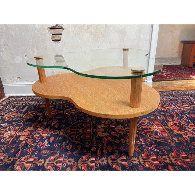 A glass and cerused oak 2 tier cloud or (3 leaf) clover shaped coffee table with carved tripod legs and brass caps. Please...