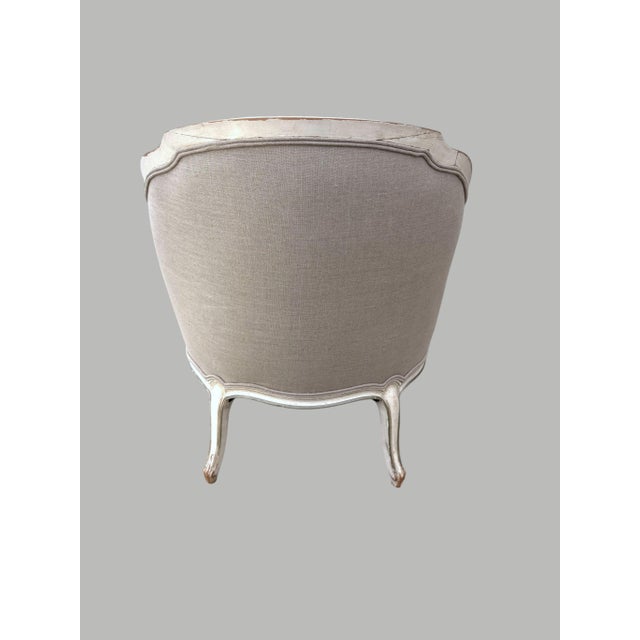 A Louis XV style chaise longue covered in linen, the frame has a distress finish due to its age.