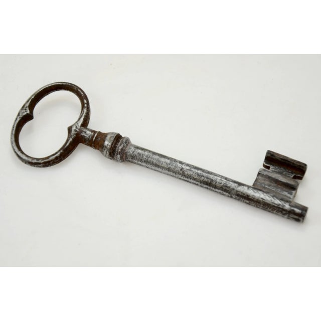 Large antique French steel gate or chateau skeleton key with classic bow head and well-defined teeth attached to a soft...